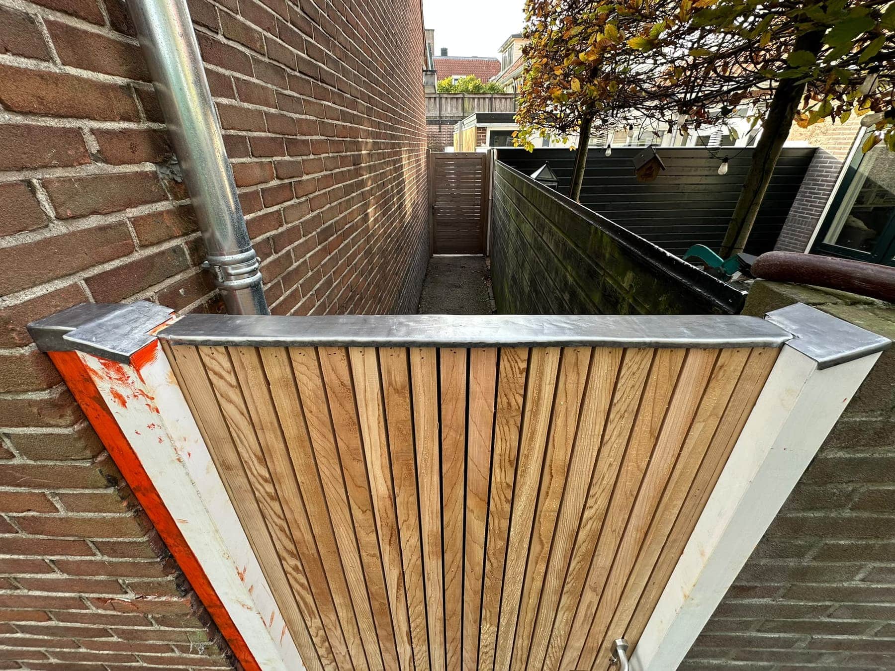 Detail van de zinken afdekking op een houten tuinpoort, timmerwerk bij Leusden